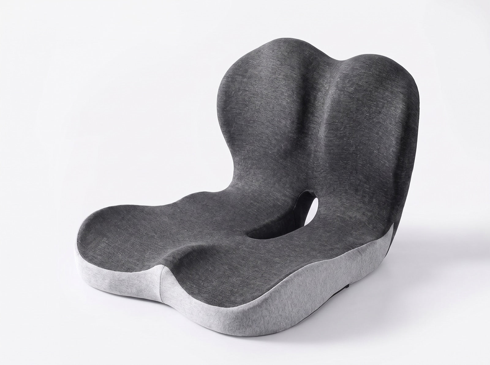 The Nemira cushion: seat platform and lumbar panel moulded as one continuous L-shaped body, with an open cutout under the tailbone